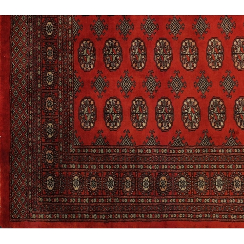 2035 - Rectangular Pakistan Bokhara design rug onto a dark red ground, 274cm x 183cm