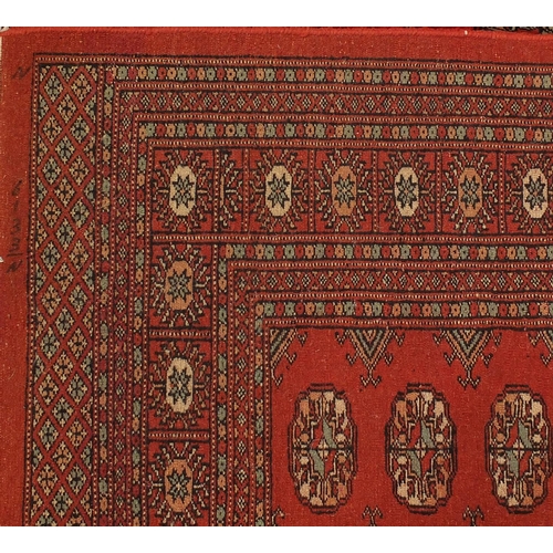 2035 - Rectangular Pakistan Bokhara design rug onto a dark red ground, 274cm x 183cm