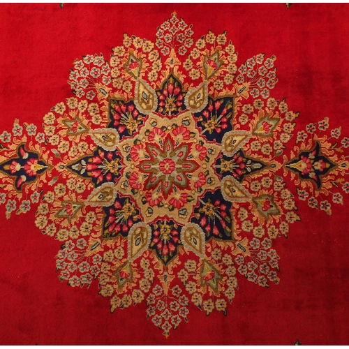2010 - Rectangular Persian Kerman carpet having all over floral motifs onto a red ground, 430cm x 305cm