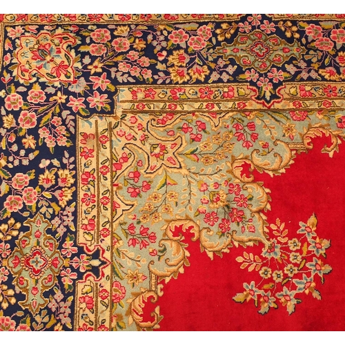 2010 - Rectangular Persian Kerman carpet having all over floral motifs onto a red ground, 430cm x 305cm