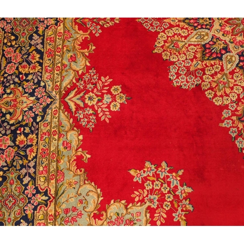 2010 - Rectangular Persian Kerman carpet having all over floral motifs onto a red ground, 430cm x 305cm
