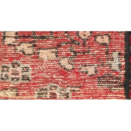 2050 - Rectangular Persian Shiraz carpet runner, having all over floral motifs onto a dark red ground, 277c... 