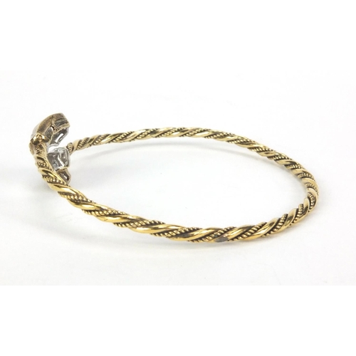 2577 - Gold coloured metal rope twist bangle set with sapphires, approximate weight 10.5g