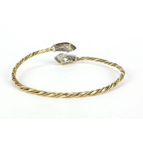 2577 - Gold coloured metal rope twist bangle set with sapphires, approximate weight 10.5g