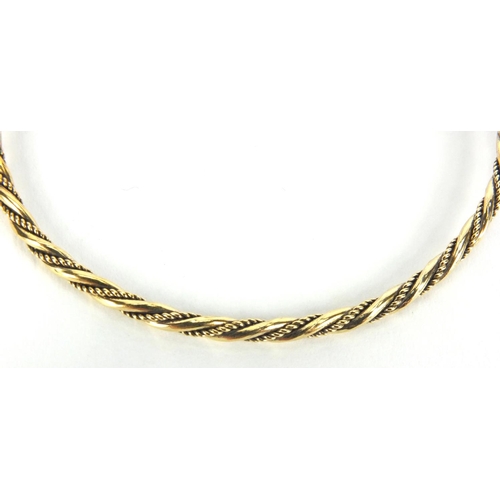 2577 - Gold coloured metal rope twist bangle set with sapphires, approximate weight 10.5g