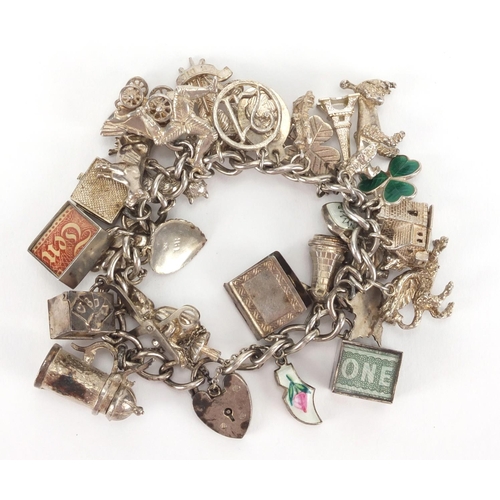 2567 - Heavy silver charm bracelet with a large selection of mostly silver charms including, emergency note... 