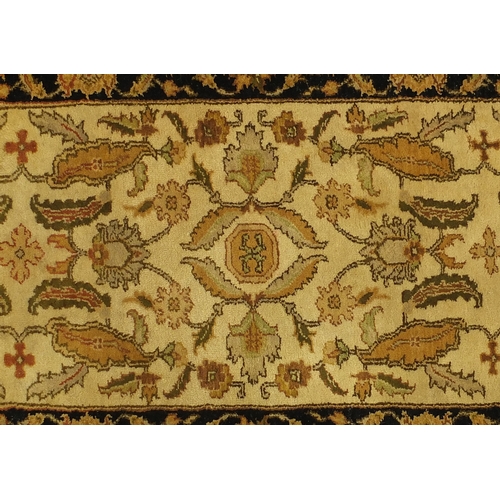 2015 - Tabriz carpet runner with stylised floral design, with black boarder on a mainly cream ground, 305cm... 