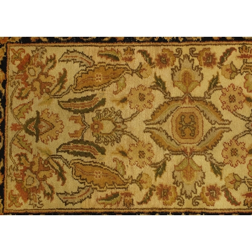 2015 - Tabriz carpet runner with stylised floral design, with black boarder on a mainly cream ground, 305cm... 