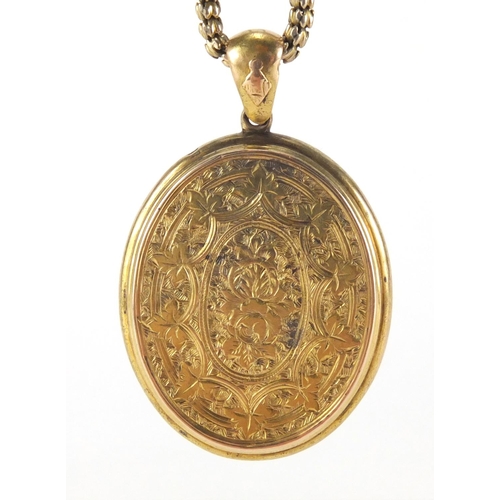 2592 - Victorian gilt metal locket with engraved decoration on a gold coloured necklace, the locket 5cm in ... 