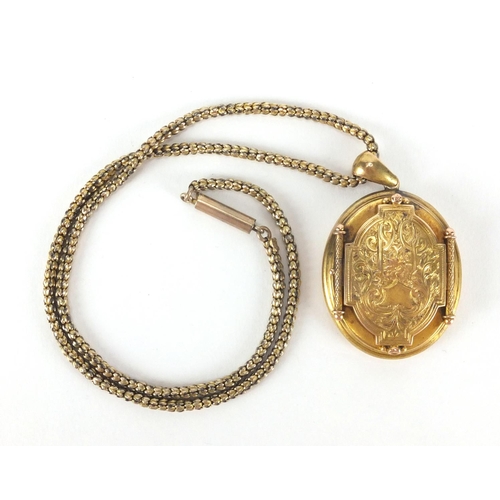 2592 - Victorian gilt metal locket with engraved decoration on a gold coloured necklace, the locket 5cm in ... 