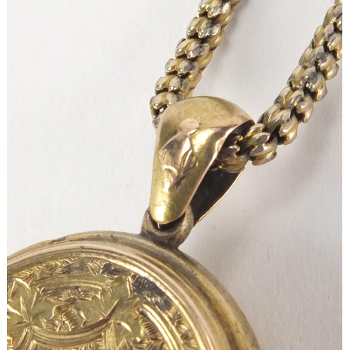 2592 - Victorian gilt metal locket with engraved decoration on a gold coloured necklace, the locket 5cm in ... 