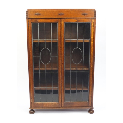 15 - Oak two door bookcase fitted with a pair of leaded glass doors, 150cm H x 92cm W x 28cm D