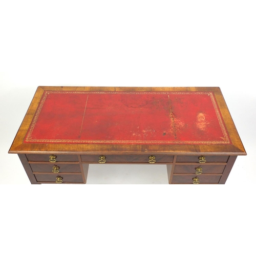 11 - Mahogany desk with tooled leather top above an arrangement of seven drawers on tapering legs, 77cm H... 