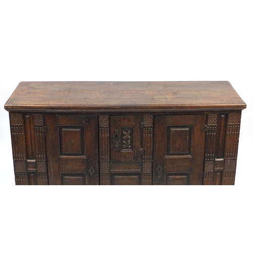 2019 - Antique carved oak court cupboard fitted with three fielded panelled doors, 104cm H x 170cm W x 57cm... 