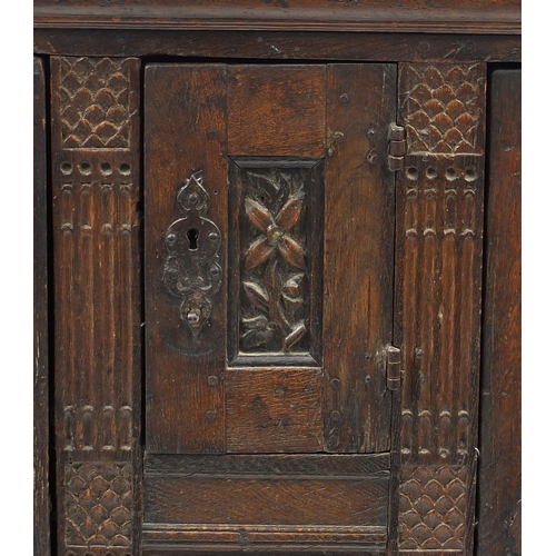 2019 - Antique carved oak court cupboard fitted with three fielded panelled doors, 104cm H x 170cm W x 57cm... 