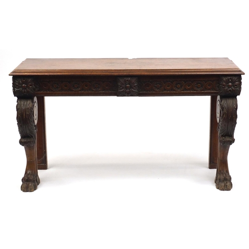 2038 - Carved oak console table fitted with two frieze drawers, raised on paw feet, one drawer stamped T Wi... 