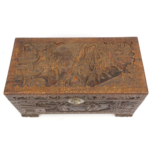2053 - Oriental camphorwood chest with twin handles, carved with warriors on horseback, 48cm H x 90cm W x 4... 