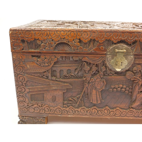 2053 - Oriental camphorwood chest with twin handles, carved with warriors on horseback, 48cm H x 90cm W x 4... 