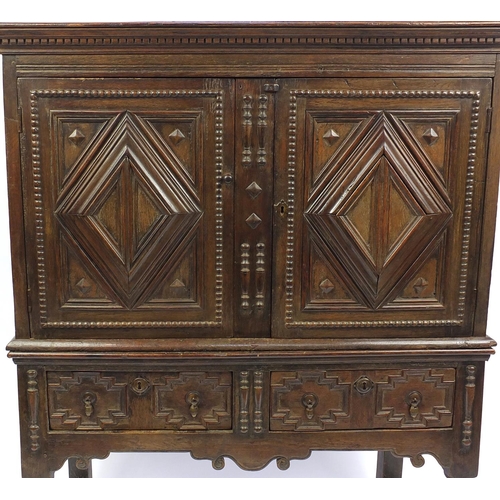 2044 - Jacobean style cabinet on stand fitted with a pair of lozenge relief doors above a pair of drawers o... 