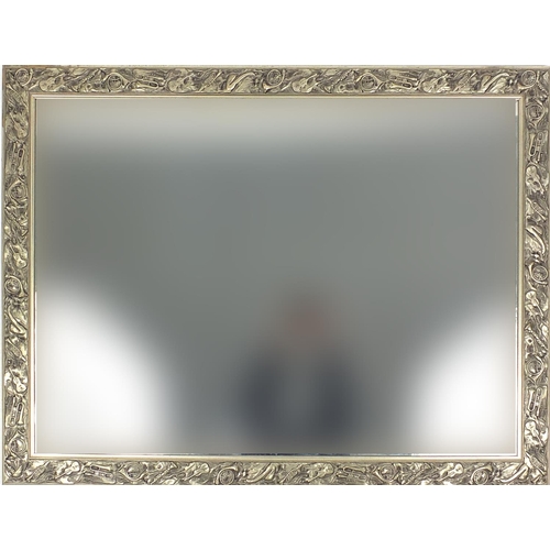 45 - Bevelled edge mirror with musical instrument decoration to the frame, 130cm x 98cm