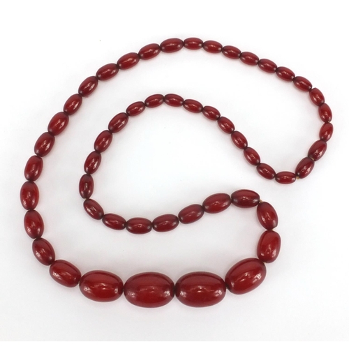 913 - Cherry amber coloured bead necklace, 66cm in length, approximate weight 45.4g