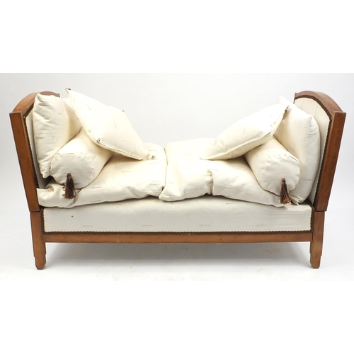 19 - Walnut framed daybed with cream upholstered cushions, 76cm H x 137cm W x 68cm D
