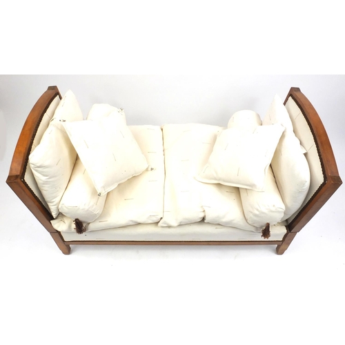 19 - Walnut framed daybed with cream upholstered cushions, 76cm H x 137cm W x 68cm D