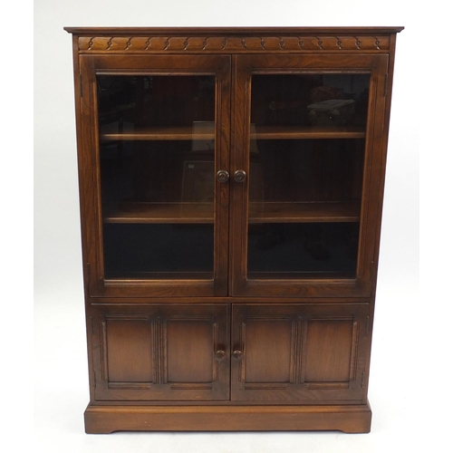 20 - Ercol stained elm book case fitted with two glazed doors above two cupboard doors, 137cm H x 100cm W... 