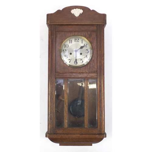 483 - Oak hanging wall clock with silvered dial and visible pendulum, 75cm in length