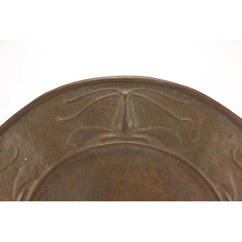 704 - Arts & Crafts copper charger, the border embossed with stylised flowers, 40cm in diameter