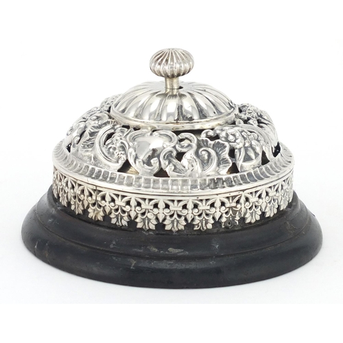 9 - Victorian silver table bell by William Comyns, with ebonised based, embossed and pierced with masks ... 