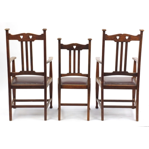 2014 - Set of six oak Arts & Crafts chairs including two carvers with carved heart splats and brown leather... 