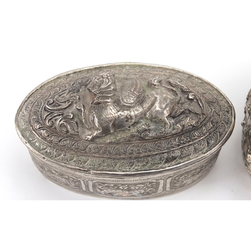 757 - Indian unmarked silver cylindrical pot and cover profusely embossed with figures and foliage, togeth... 