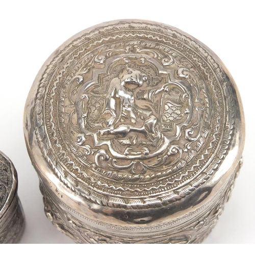 757 - Indian unmarked silver cylindrical pot and cover profusely embossed with figures and foliage, togeth... 