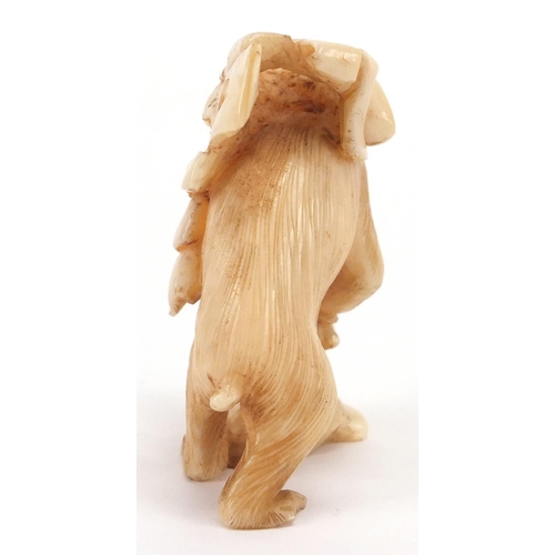 506 - Japanese carved ivory okimono of a monkey at work carrying fruit, 6cm high