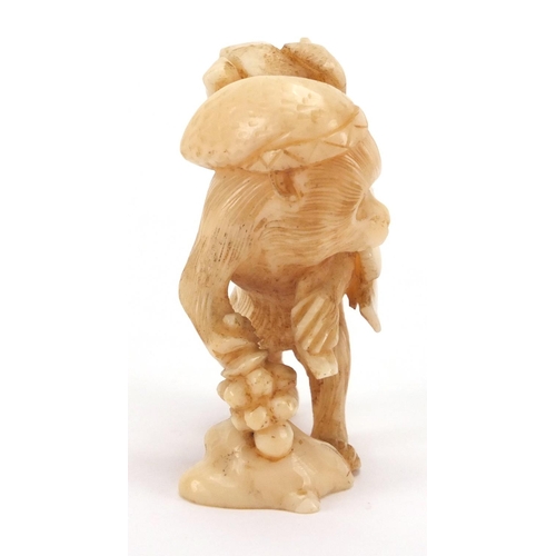 506 - Japanese carved ivory okimono of a monkey at work carrying fruit, 6cm high