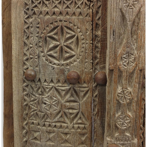 572 - Pair of Indian hardwood and iron shutters, possibly 17th century Gujarati, 155cm high x 120cm wide