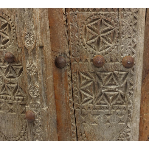 572 - Pair of Indian hardwood and iron shutters, possibly 17th century Gujarati, 155cm high x 120cm wide