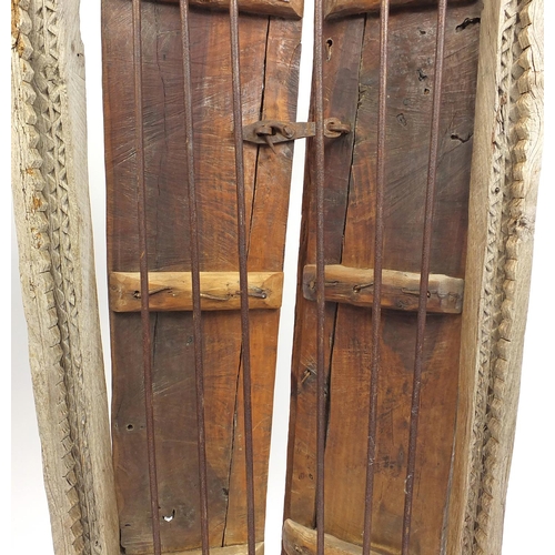 572 - Pair of Indian hardwood and iron shutters, possibly 17th century Gujarati, 155cm high x 120cm wide