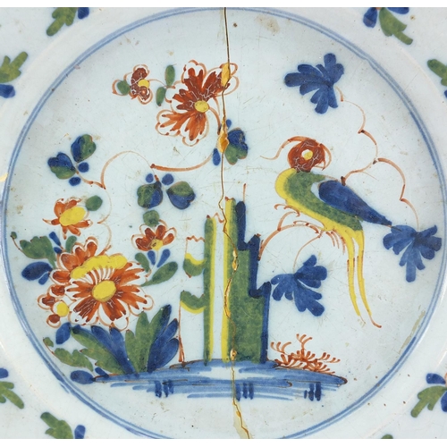 593 - Delft tin glaze pottery charger, hand painted in blues, greens, yellows and oranges with a stylised ... 