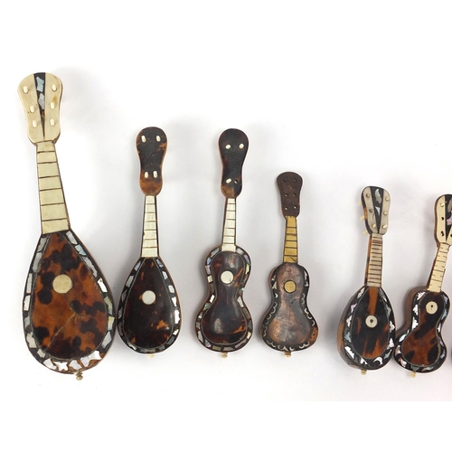 23 - Nine tortoiseshell ivory and Mother of Pearl miniature musical instruments, the largest 20cm in leng... 