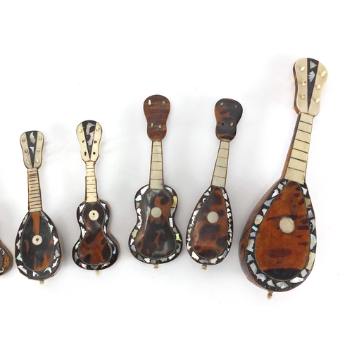 23 - Nine tortoiseshell ivory and Mother of Pearl miniature musical instruments, the largest 20cm in leng... 
