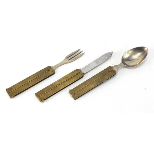 115 - Military interest brass and stainless steel folding campaign cutlery housed in a leather case, with ... 