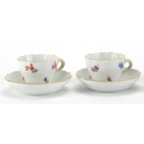 583 - Four Meissen tea cups and saucers, each hand painted with flowers and with crossword marks to the ba... 