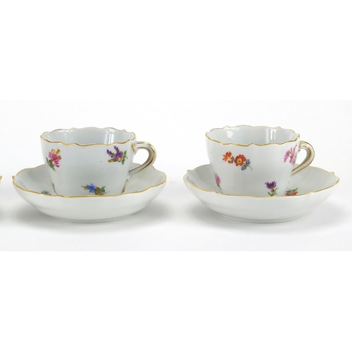 583 - Four Meissen tea cups and saucers, each hand painted with flowers and with crossword marks to the ba... 