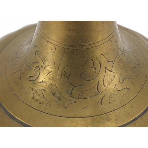 559 - Persian brass water dropper, engraved with flowers, signed around the foot rim, 35cm high