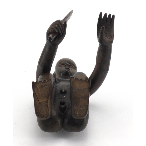 570 - African tribal interest wood carving of a crouching figure carving a nut with articulated arms, 37cm... 