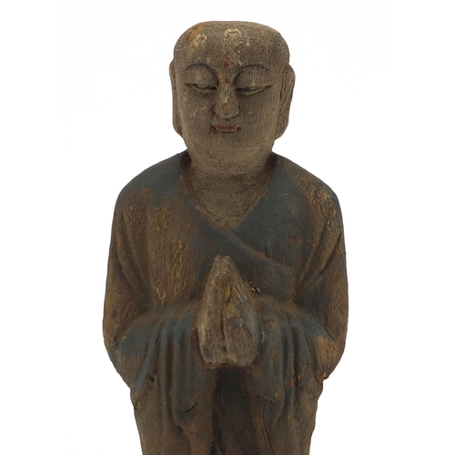 466 - Chinese carved wooden figure of Buddha with remnants of paint, 31cm high