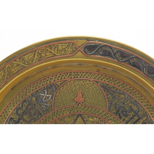 551 - Egyptian Cairoware brass tray with silver and copper inlay decorated with script and star motif, 29c... 