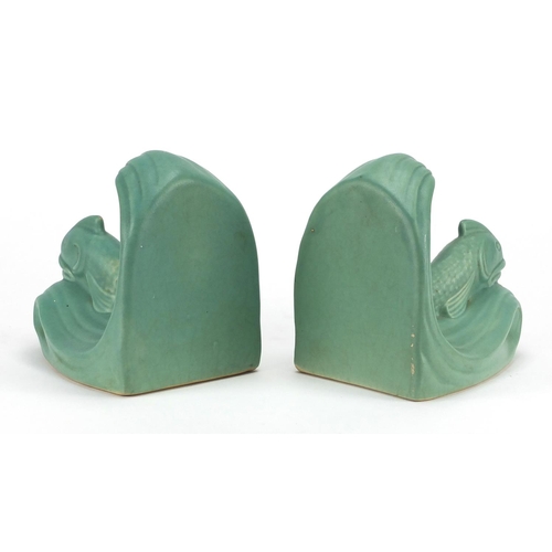 662 - Pair of Langley green glazed pottery bookends, both of dolphin form and with factory marks to the ba... 